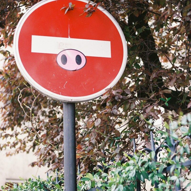 A stop sign with a pig's face drawn face